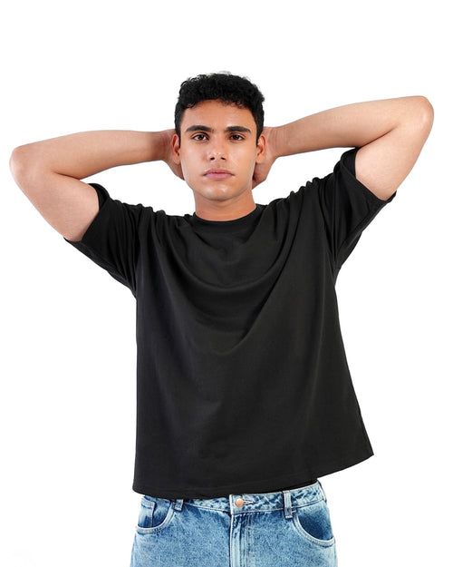 Minstreet unisex boxy fit black tshirt, oversized drop-shoulder cut, front view on male model